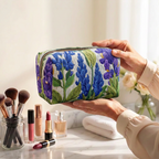 Trousse de maquillage matelassée Fleur de Lumière tenue en main près de la coiffeuse