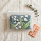 Trousse de maquillage matelassée Lys Gracieux emballée dans une pochette Maison Bruges