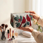 Trousse de maquillage matelassée Plume Rouge tenue en main près de la coiffeuse