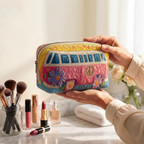 Trousse de maquillage matelassée Escapade Sereine tenue en main près de la coiffeuse