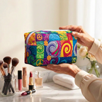 Trousse de maquillage matelassée Esprit de Paix tenue en main près de la coiffeuse