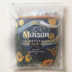 Panier à linge matelassé Chat malin, plié à plat dans l’emballage Maison Bruges