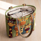 Grâce de la Savane Sac Matelassé – sac rempli d’un livre, d’un gilet et de lunettes